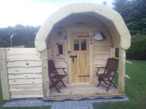 a small wooden shed with two chairs in it at Ferienhaus Gerda in Osteel