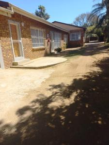 a brick house with a driveway in front of it at Dafel street Guesthouse in Piet Retief