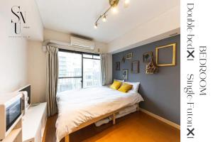 Una cama o camas en una habitación de 402 道頓堀側のお部屋 中心地へのアクセス抜群 ダブルベッド1台