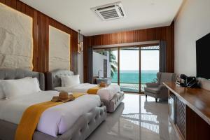 zwei Betten in einem Zimmer mit Meerblick in der Unterkunft Hotel Villa AoKhanom Beachfront in Khanom