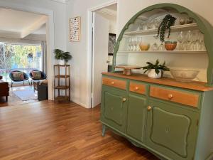 a green dresser in a living room at The Hideaway Long Beach - WIFI in Robe