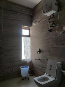 a bathroom with a toilet and a window at Hotel Spiti Heritage in Kaza