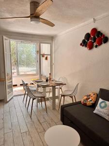 ein Wohnzimmer mit einer Couch und einem Tisch und Stühlen in der Unterkunft Miramar By Bellavista - 250 m de la plage - terrasse in Argelès-sur-Mer