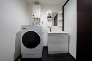 a bathroom with a washing machine and a sink at Norwegian Wood in Kita-sanjō