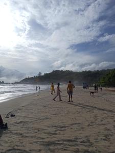 a group of people walking on the beach at Om Ganesh Naik Guest House in Arambol