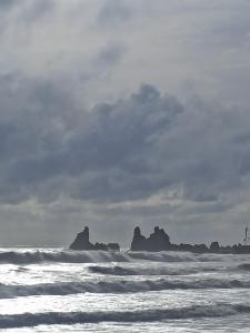 a beach with waves and rocks in the ocean at Om Ganesh Naik Guest House in Arambol