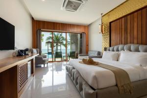 ein Hotelzimmer mit einem großen Bett und einem Fernseher in der Unterkunft Hotel Villa AoKhanom Beachfront in Khanom