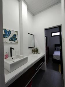 a white bathroom with a sink and a bed at Villa Casablanca in Montongbuwoh +50 photos