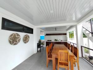 a dining room with a wooden table and chairs at Rumah Casablanca in Montongbuwoh