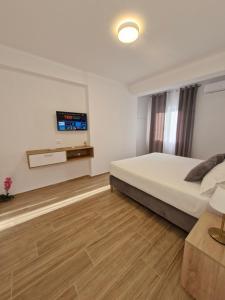 a bedroom with a bed and a tv on the wall at Villa Virginia in Sarandë