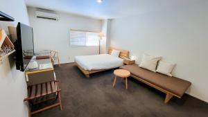 a small bedroom with a bed and a table at You Style Hotel MARINE in Kagoshima