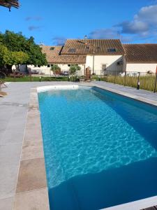 a large blue swimming pool in front of a house at Chambre d'hotes Mas Pékin in Mas-Thibert