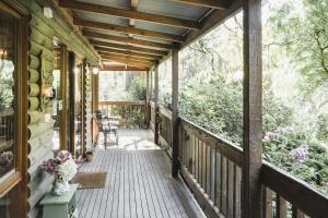 a porch of a house with a wooden deck at Botanica Retreat in Olinda