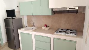 a kitchen with a sink and a refrigerator at Dimora di Ponente in Ostuni