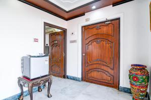 une pièce avec une porte en bois et une télévision sur une table dans l'établissement Palette - Hotel ICON Bakkhali, à Bakkhali 47 autres photos