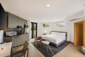 ein Schlafzimmer mit großem Bett und eine Küche in der Unterkunft Malibu Sand Carbon Beach Suites in Malibu