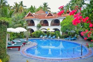 a resort with a swimming pool in front of a building at Molly's Retreat in Kovalam