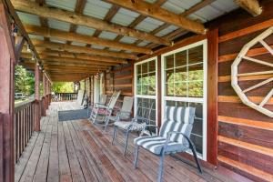 a porch with chairs and windows on a cabin at Hillbilly Highrise in Sevierville +34 photos