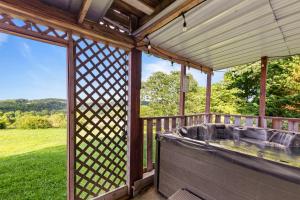 an outdoor hot tub on a deck with a view of a field at Hillbilly Highrise in Sevierville