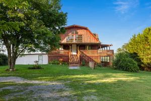 a large wooden house with a tree in the yard at Hillbilly Highrise in Sevierville