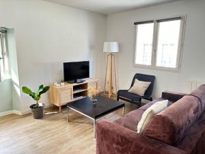 a living room with a couch and a tv at Appartement duplex cosy Saint Servan centre in Saint Malo