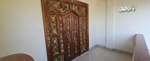 an ornate wooden door in a room at Rinjani Trekking Center in Senaru
