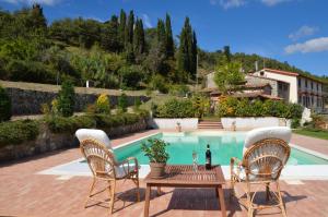 un patio con tavolo e sedie accanto alla piscina di Casa al Vento a Talla