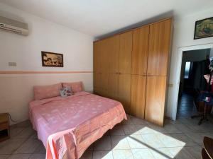 a bedroom with a bed and a wooden cabinet at Holiday Rome Hub Villa Camilla in Fiumicino +81 photos