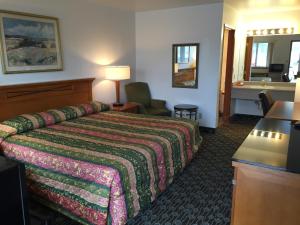 a hotel room with a bed and a sink at Sunshine Motel in Fife