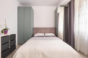 a bedroom with a large bed and a window at A&A Luxury Apartment in Giroc
