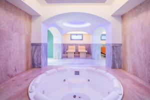 a large white bath tub in a room at Hotel Hanioti Village Spa in Hanioti