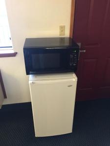 a microwave sitting on top of a refrigerator at Sunshine Motel in Fife