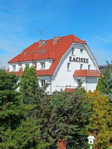a large white building with a red roof at Willa Zacisze Sianożęty in Sianozety