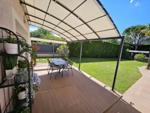 un patio avec une table et des chaises sous une pergola dans l'établissement le stockholm, à Sablons