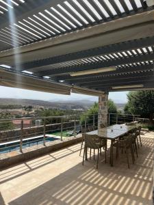 a patio with a table and chairs on a deck at Charlise Luxury Villa by Cretevasion in Anópolis