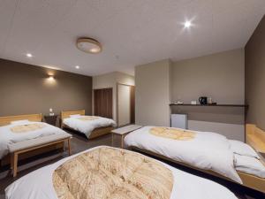 a hotel room with two beds with white sheets at Miyama Nature and Culture Village Kajikaso in Nakamura +55 photos