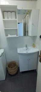 a white bathroom with a sink and a mirror at Apartman Kozarčeva in Varaždin +12 photos