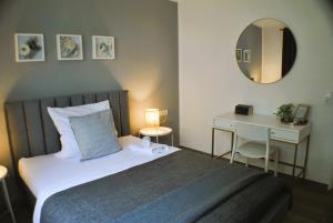 a bedroom with a bed and a desk and a mirror at Ferienwohnung Marina Kassel in Kassel