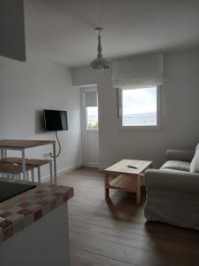 un soggiorno con un divano e un tavolo di Hostal Terraza Miramar SL a Boiro