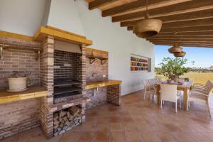 a kitchen with a brick fireplace and a table with chairs at Finca Sa Sort in Santanyi