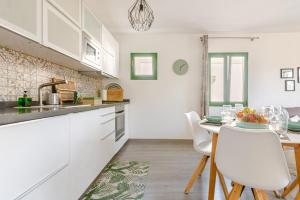Una cocina con gabinetes blancos y una mesa y sillas. en La Flor Beach, en Puerto de Mogán