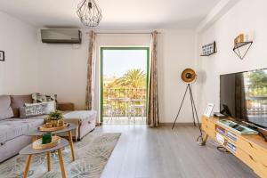 Una sala de estar con un sofá y un televisor. en La Flor Beach, en Puerto de Mogán