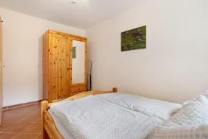 a bedroom with a bed and a wooden cabinet at Haus Seeadler Wohnung 8 in Ostseebad Koserow