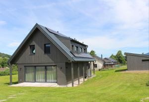 a house with a gambrel roof on a green lawn at Chalupa U Krtka in Bělá pod Pradědem