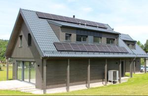 a house with solar panels on top of it at Chalupa U Krtka in Bělá pod Pradědem