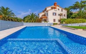 a villa with a swimming pool in front of a house at Studio Percan in Premantura