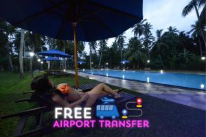 a woman sitting on a lawn chair next to a pool at Oreeka - Katunayake Airport Transit Hotels in Katunayake