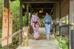 two people in kimonos walking down a walkway at Setsugetsuka in Hakone