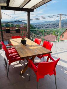 萨拉热窝Sarajevo Cozy Attic - Free Parking的庭院里设有一张木桌和红色椅子