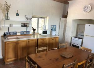 a kitchen with a wooden table and a microwave at The Hideaway Robe SA Centrally located in Robe